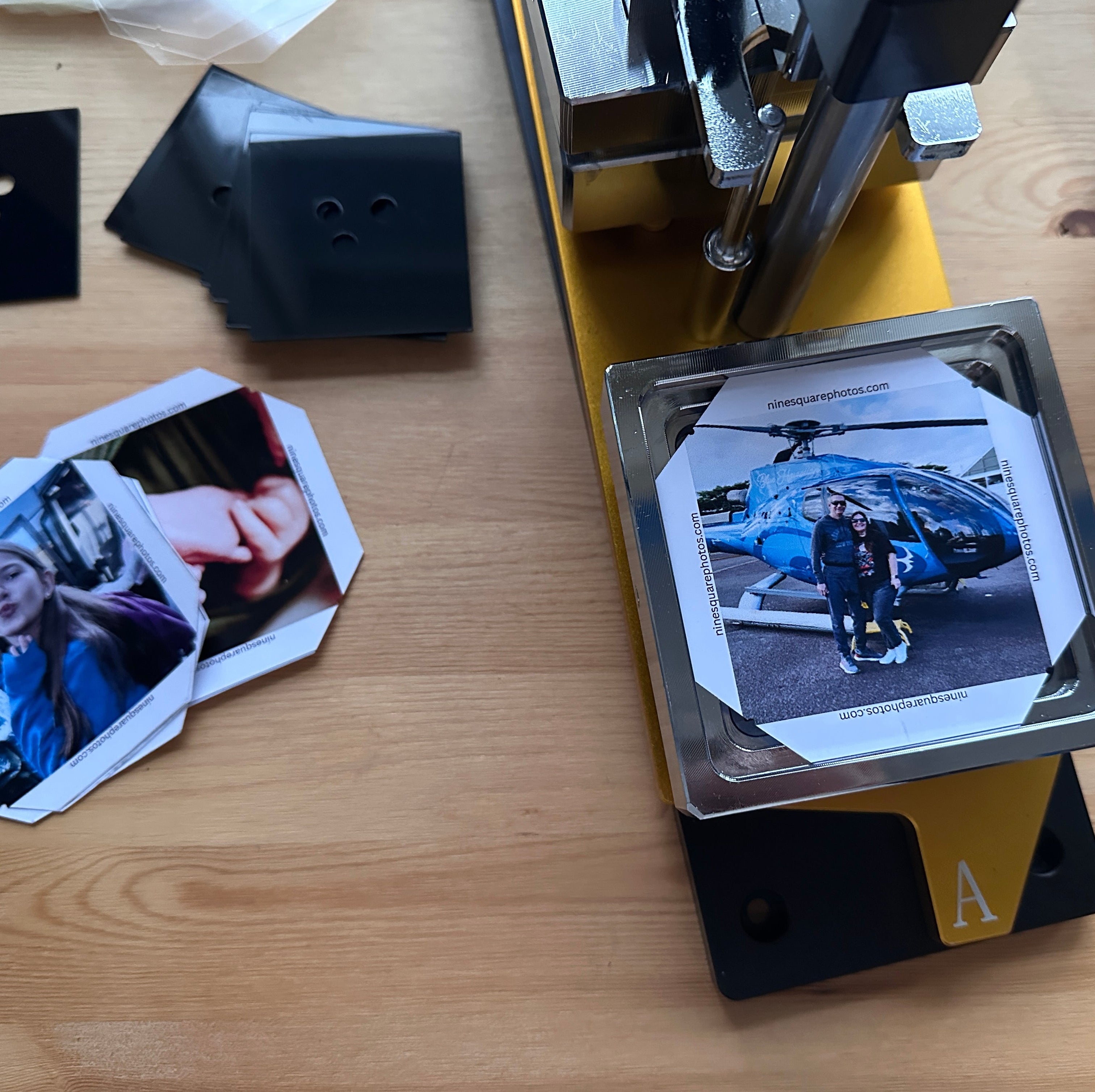 Photo printing process on a wooden table with printed photos and a photo making machine memory making