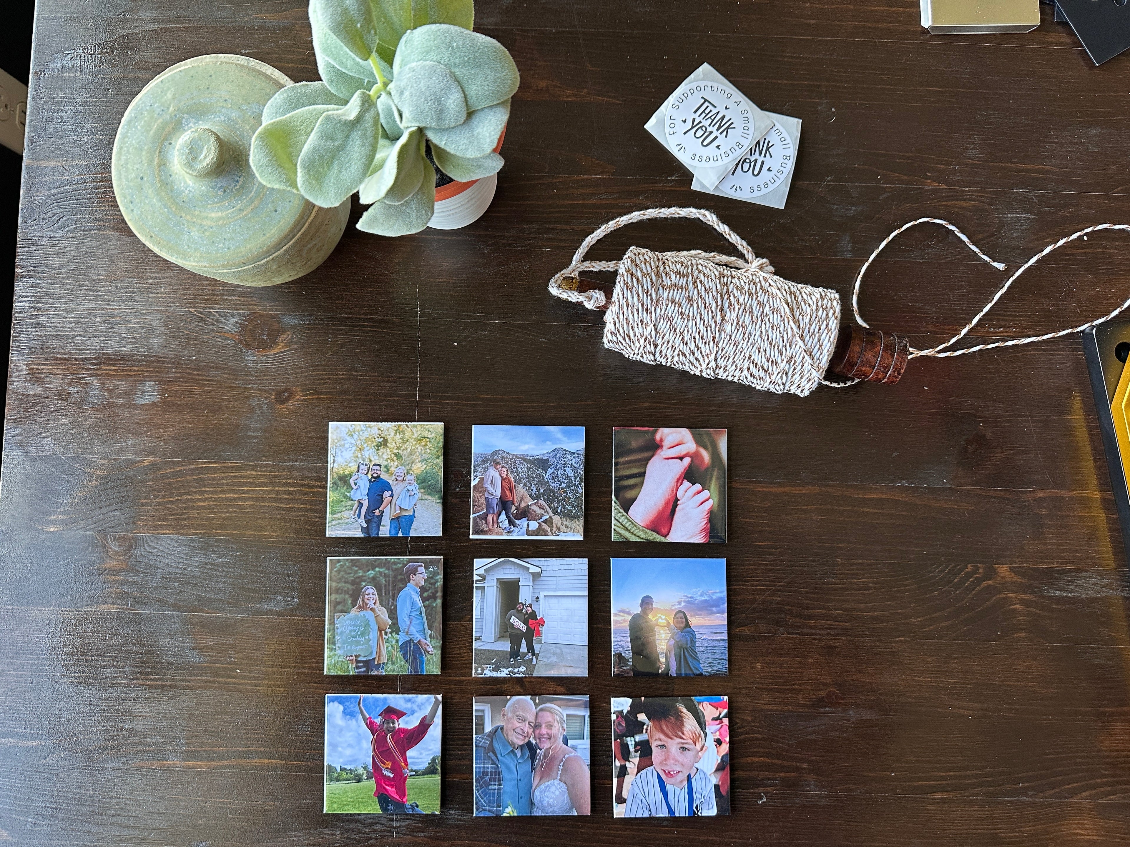 Nine Smallmemory magnets on a wooden table. graduation baby announcement baby feet vacation loved one family photos wedding